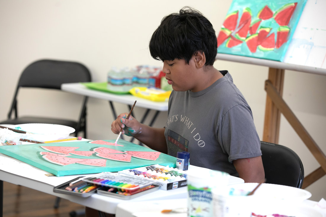 Student painting in art classroom at Catherine Carter Art School at Hatch Street Studios in New Bedford.